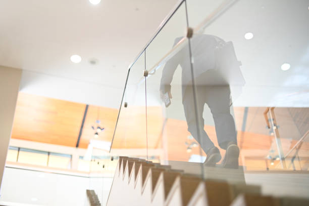 istock Businessman waking up stairs holding smartphone, anyonomous 1164554759