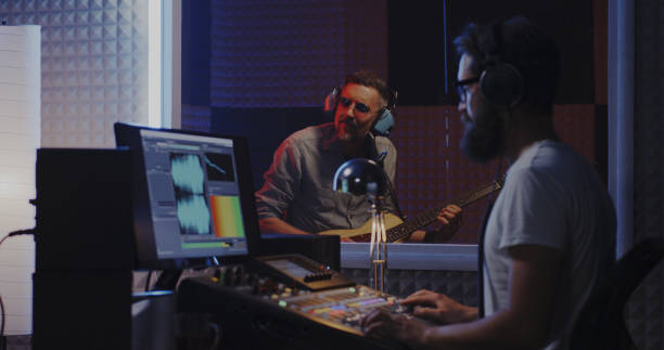 istock Guitarist and sound engineer working in studio 1164554772