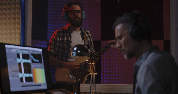 istock Guitarist and sound engineer working in studio 1164554773
