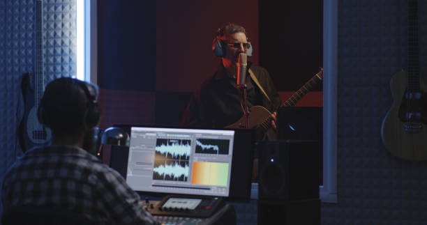 istock Guitarist and sound engineer working in studio 1164554802
