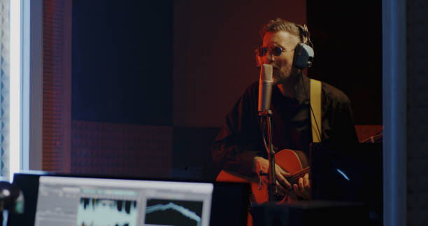 istock Guitarist and sound engineer working in studio 1164554838