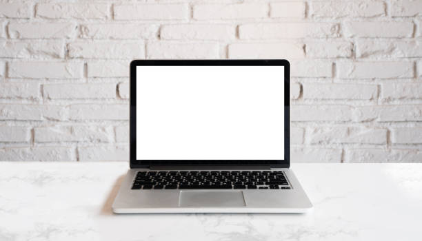istock Conceptual workspace, Laptop computer with blank white screen. Mock up laptop on wood table and white brick wall. 1164555292