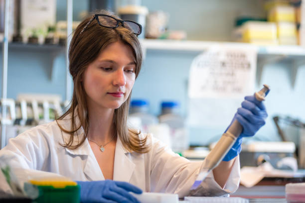 Woman working in biotechnology biomedical laboratory White woman working in molecular biology laboratory crispr photos stock pictures, royalty-free photos & images