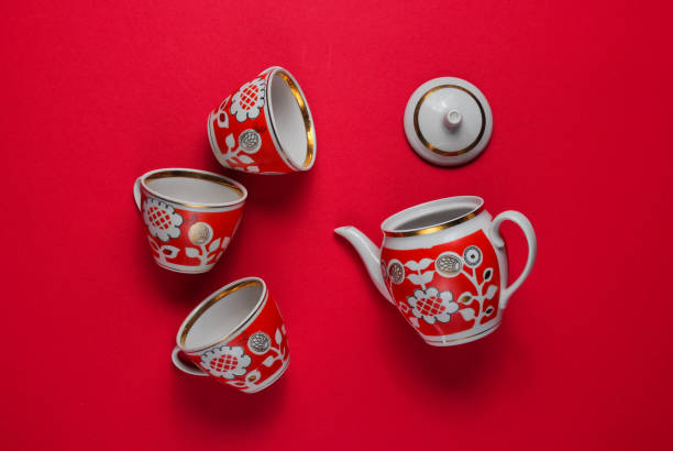 istock Retro ceramic cups and teapot on a red background. Top view 1164558326