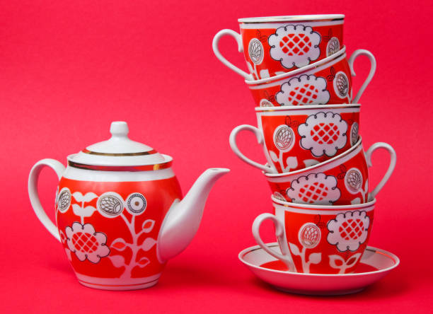 stapel von retro-keramik-tassen und teekanne auf rotem hintergrund. ansicht von oben - old fashioned tea cup victorian style beauty stock-fotos und bilder