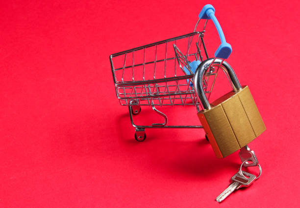 istock Minimalistic shopping concept. Mini shopping trolley with a lock on red background. 1164559584