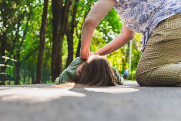 Old woman giving cardiopulmonary resuscitation to help a fainted girl stock photo