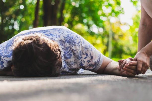 istock Old woman lying on the ground helped by citizen 1164559940