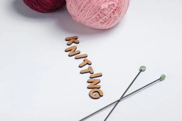Home hobbies concept. Wool balls of thread, knitting needles on a white background
