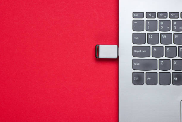 laptop con unità flash su sfondo rosso. vista dall'alto - red laptop usb flash drive computer key foto e immagini stock