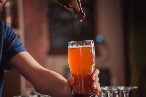 istock Bartender pouring beer in a glass at bar counter 1164561303