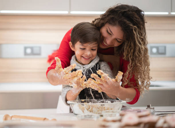 クッキーを焼く楽しみを持っている母と息子 - mother son family cooking ストックフォトと画像