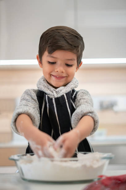 istock Happy boy baking cookies in the kitchen 1164561329