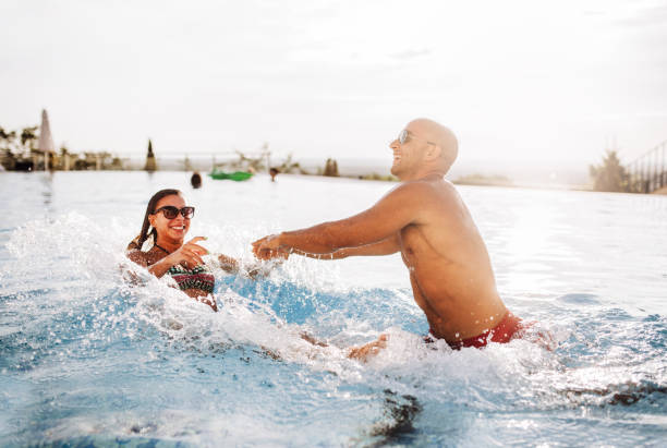 istock Happy couple  in luxury hotel pool 1164561379