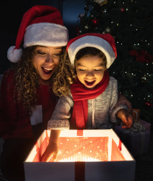 szczęśliwa matka i syn otwarcie prezentów na wigilię - giving christmas lifestyles holiday zdjęcia i obrazy z banku zdjęć