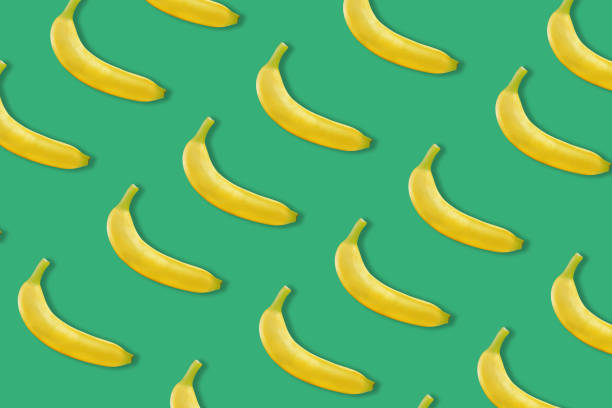 istock Colorful fruit pattern of fresh yellow bananas on colored background 1164565653