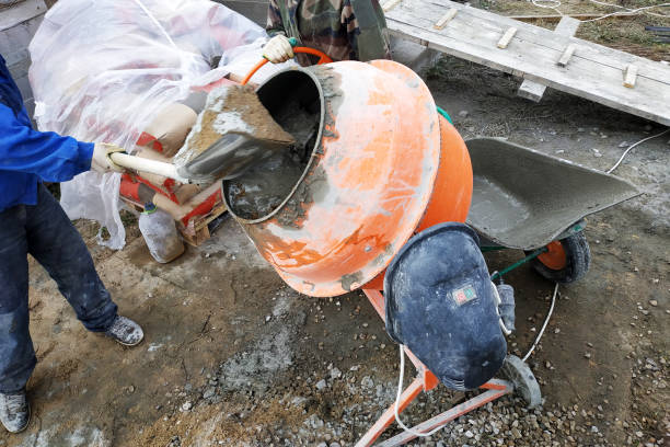 istock auxiliary worker develops a cement mortar in a concrete mixer at the construction of a country house 1164566838
