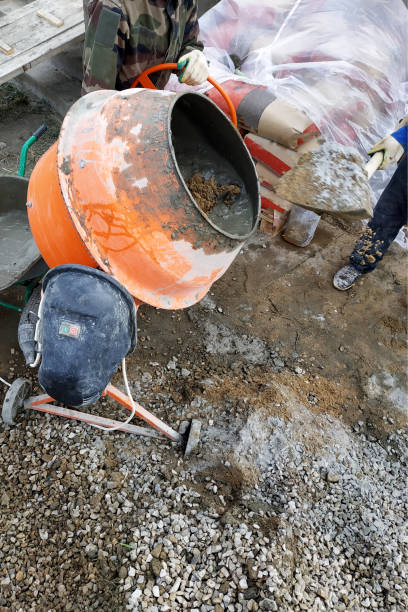 istock auxiliary worker develops a cement mortar in a concrete mixer at the construction of a country house 1164566859