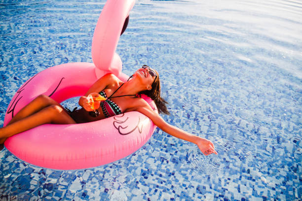 istock Female Enjoying Sunset in  Swimming Pool 1164567028