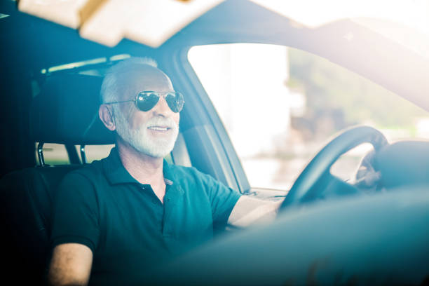 istock Happy senior man driving a car. 1164572048