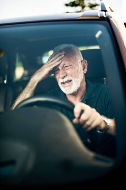istock Senior man having a strong headache while driving a car. 1164572248