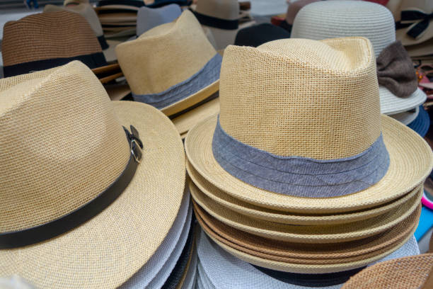 istock Woven tan grey and white hats on display at the market 1164579219