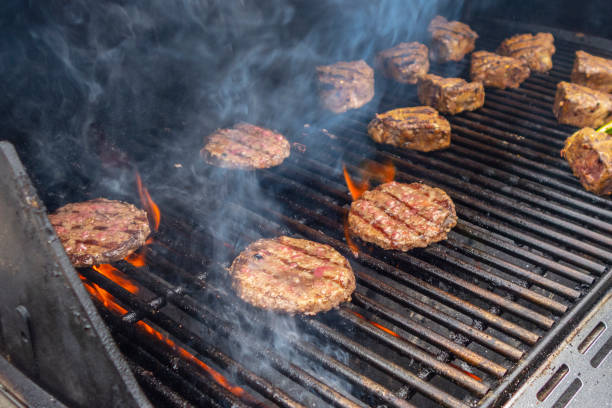 istock summer beef hamburger and lamb chops  BBQ on a propane gas grill flames 1164579344