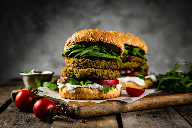 istock Vegan zucchini burger and ingredients on rustic wood background 1164580346