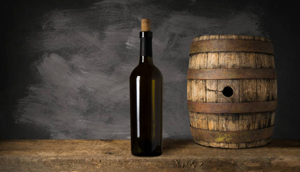 istock Bottle of red wine with a corkscrew. On a black wooden background. 1164581321