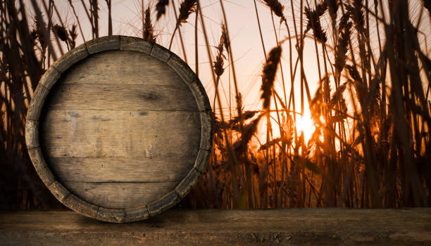 Wooden barrel on a old oak table. Black background behind.