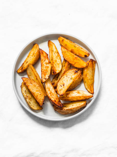 istock Simple rustic baked potato slices on a light background, top view 1164582368