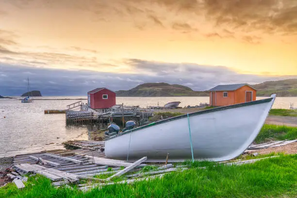 Boats and sheds in coastal fishing village during sunset in Newfoundland, Canada