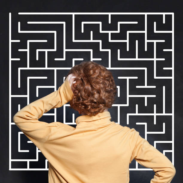 istock Little boy and maze on chalkboard background 1164584340