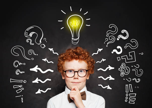 istock Redhead kid boy with lightbulb on blackboard background. Brainstorming and idea concept 1164584346