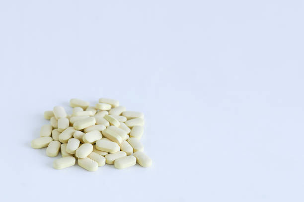 istock Beige pills loose in a pile. On a white background. 1164585340