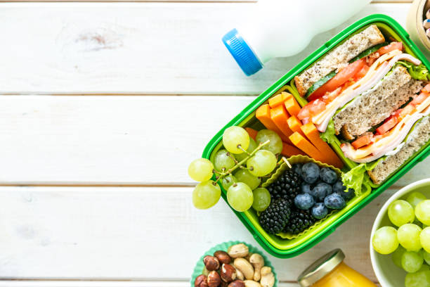 istock Back to school concept - lunch box with juice, apple and banana 1164586083