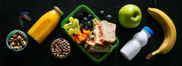 concept de retour à l'école - boîte à lunch avec le jus, la pomme et la banane - lunch packed lunch lunch box apple photos et images de collection