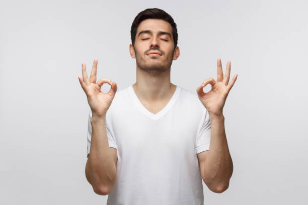 istock Concentrated man standing with closed eyes, having relaxation while meditating, trying to find balance and harmony. Yoga and meditation concept 1164586457