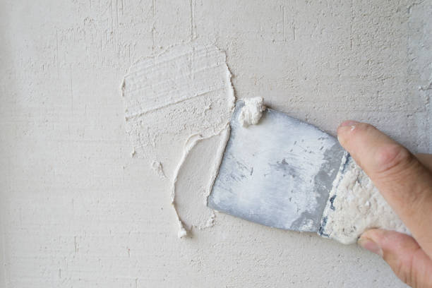 istock Putty the wall with an old spatula. 1164588299