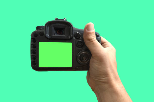 istock Camera in hands on isolated green screen, path included 1164589239