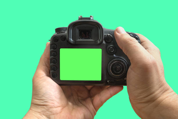 istock Camera in hands on isolated green screen, path included 1164589245