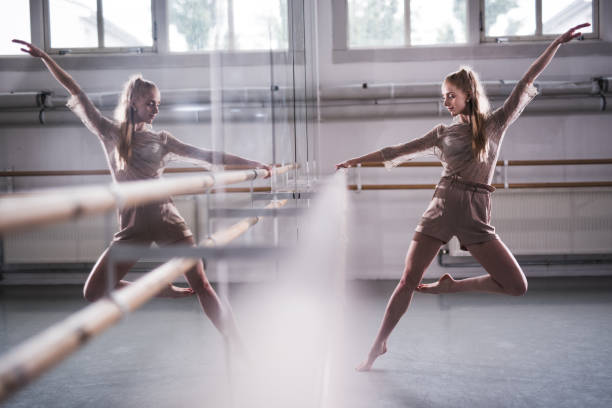 Jazzy ballerina in ballet studio. Young beautiful woman working hard indoors. dance studio mirror stock pictures, royalty-free photos & images