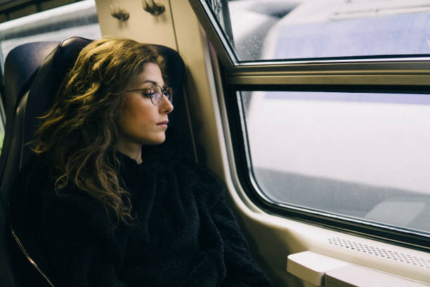 istock Young sad woman on a train 1164592736