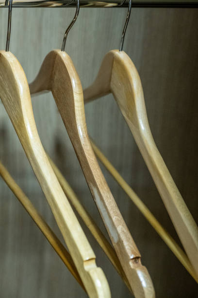 istock three empty wooden hangers in the closet 1164593603