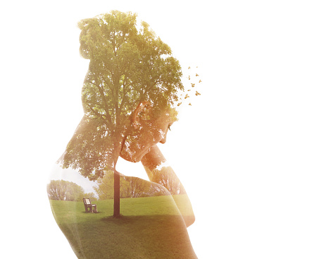 Multiple exposure of a young woman and public park