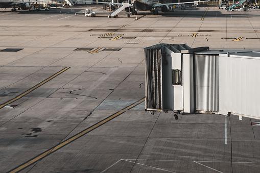 Stansted, England - July 7, 2019: An empty gate at Stansted International Airport, waiting arrival of incoming plane.  In the distance are a set of gates dedicated to Ryanair, a lowcost Irish airline.