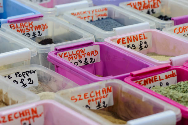 Herbs and spices in plastic containers at a market stall.