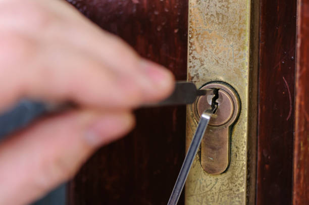 A Man Uses Lockpicking Tools To Pick The Lock Of A House Stock