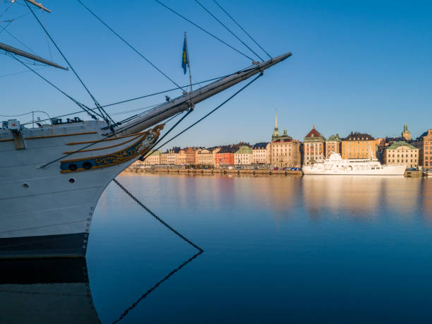Waterfront and tall ship, Gamla Stan, old town Stockholm, Sweden. Gamla Stan, the 13th century old town of ancient narrow alleyways, cobbled streets, courtyards, churches, iconic merchants houses and buildings of the Stortorget as well as royal residences now houses night clubs, bars and restaurants and is a popular tourist attraction in Stockholm, Sweden