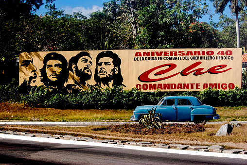Pinar del Rio, Cuba - January 8, 2008: Billboard celebrating Che Guevara with blue classic car driving by